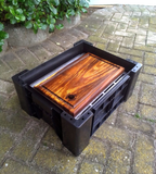 Swarthout-steakbord bo-op die braaistel in die oop AmmoBox.