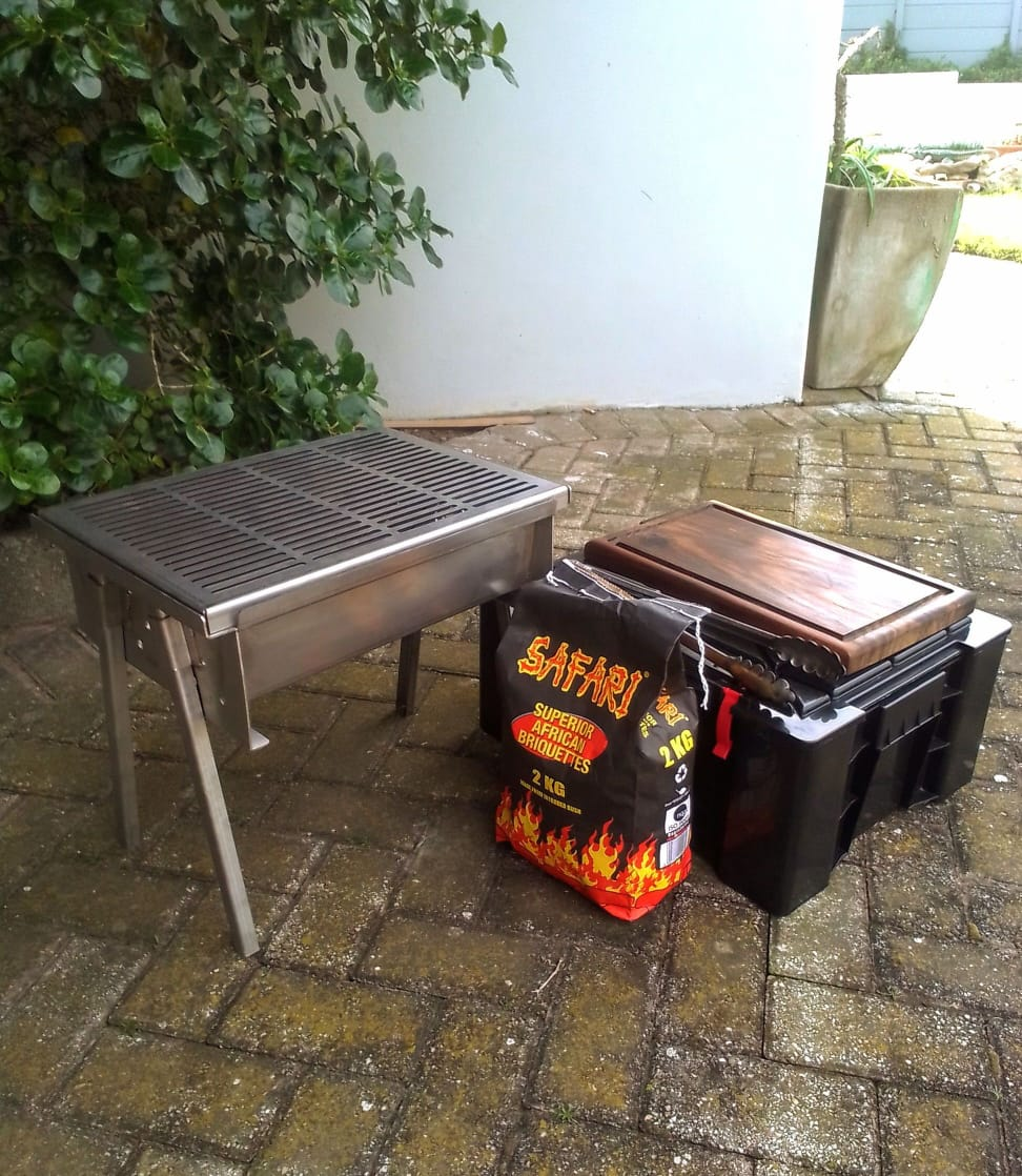 AmmoBox Braai Stel op bene met steakbord, charcoal en stoorboks.