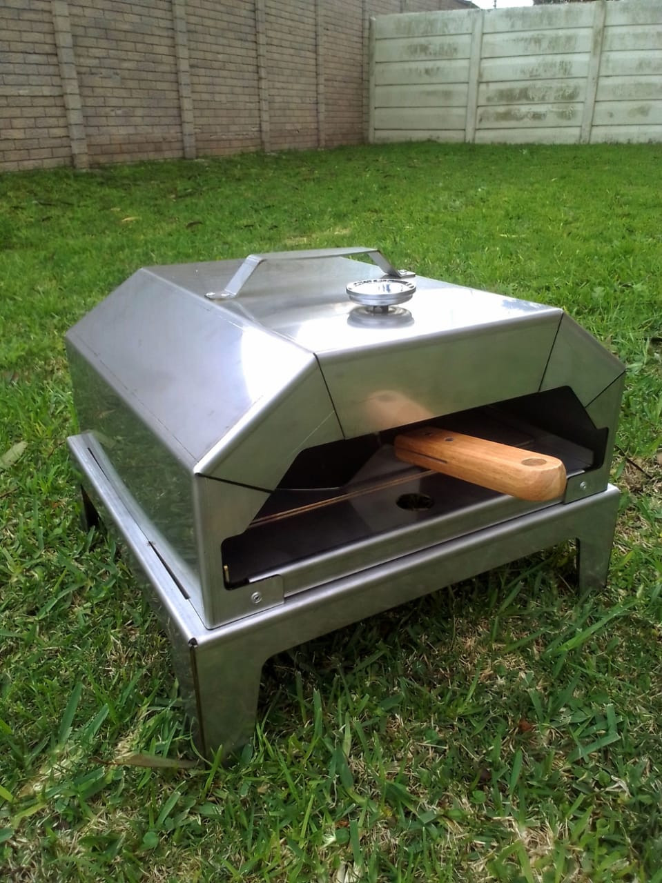PizzaBraai Kit met temperatuur meter bo-op, pizza spaan en voetstuk.